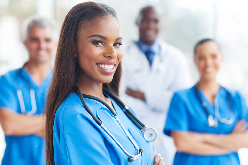 happy african female nurse with colleagues on background